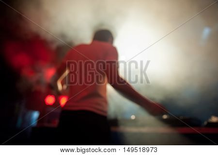 DJ performs at night disco blurred background
