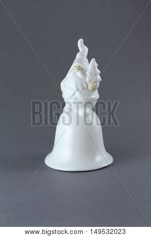 Decorative christmas figurine bell Santa Claus on gray backgroun