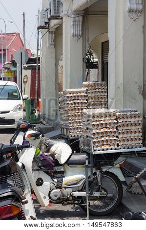 GEORGETOWN PENANG MALAYSIA - April 18 2016: Lot of chicken egg packaged on a scooter waiting for customer near a small cafe. Fresh eggs ready for distribution.