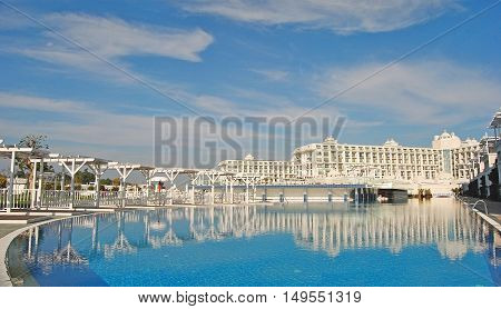Kadriye, Turkey - February 20, 2014. Building of Titanic Deluxe hotel in Kadriye resort town, with clouds and reflections in swimming pool.