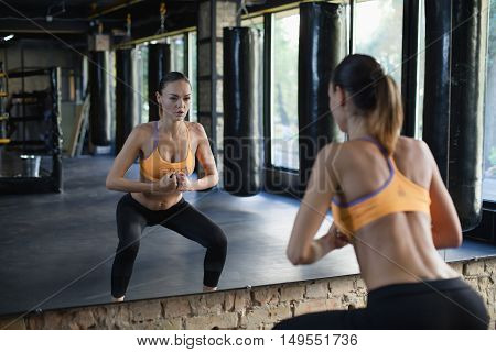 Muscular woman in a gym doing heavy weight exercises. Young woman doing weight lifting at health club.