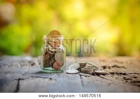Saving money coins in the bottle on wooden background