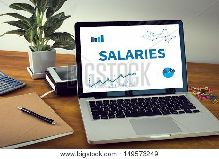 CANCER TREATMENTSALARIES Laptop on table. Warm tone