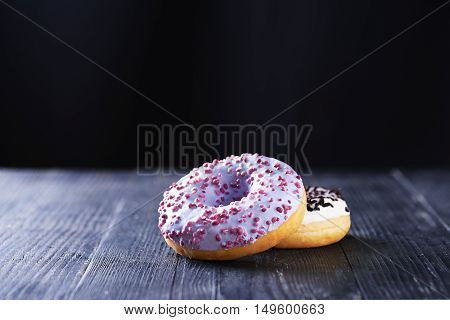 Donuts With Blue And Vanilla Icing On A Dark Background