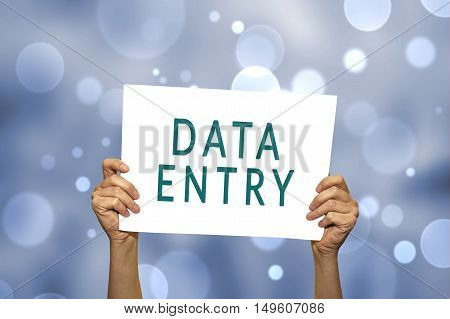 DATA ENTRY card in hand with abstract light background. Selective focus.