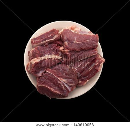 Ingredient cooking food - fresh pork ribs on a beige plate on a black background