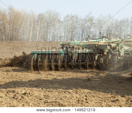 Harrowing the soil with disc harrows in spring in Ukraine.