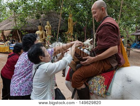 Chiang Rai, Thailand - May 21, 2016: Buddhist Monk Receiving Alms From Local People In Golden Horse