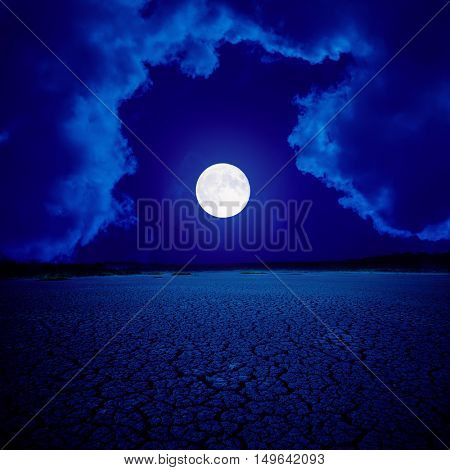 supermoon in clouds over desert