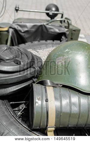 Old military helmet. Detail with old military helmet placed over car tire.