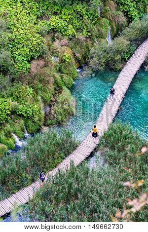 PLITVICE CROATIA - SEPTEMBER 15: Detailed view of a bridge in Pltivice lakes with tourists walking along on September 15th 2016 in Plitvice