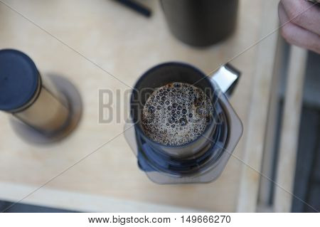 Man making fresh aeropress coffee in nature