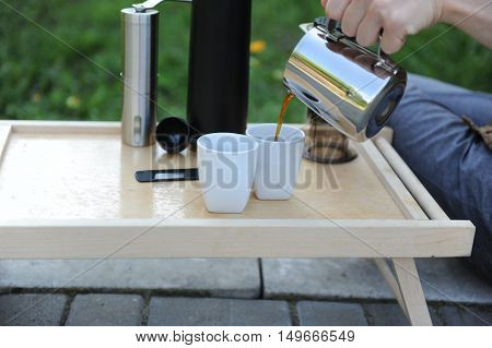 Man making fresh aeropress coffee in nature