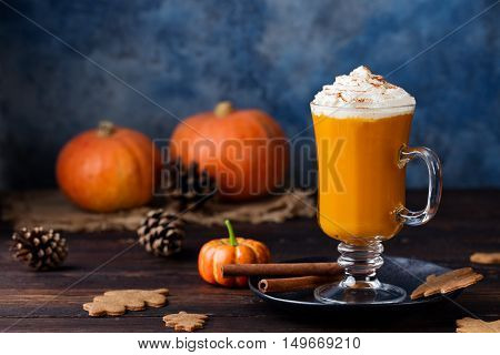 Pumpkin spice latte, smoothie, Boozy cocktail with whipped cream on top on a wooden background. Copy space