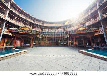 Luodai, Sichuan Province, China - Jan 16, 2016 : Hakka traditional round house with sunrays above the roof.