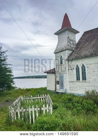A small fenced off graveyard by an abandoned church