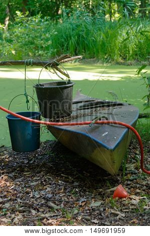 Old canoe ashore the pond is almost sunk
