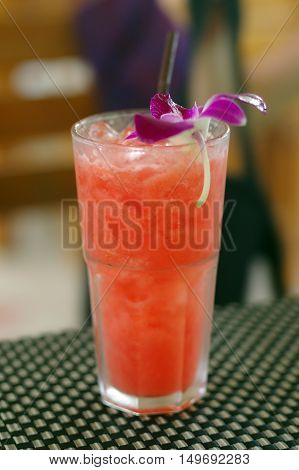 a watermelon shake with a straw and a mint leaf.