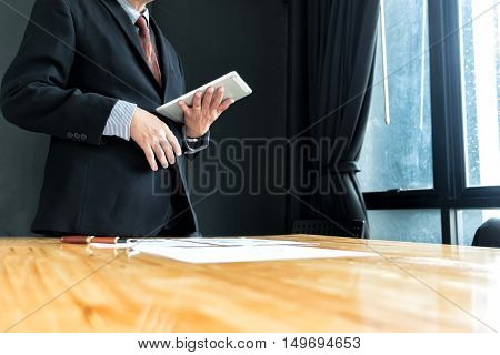 businessman in suit looking and tink vision of business with tablet in office business concept soft focus vintage tone