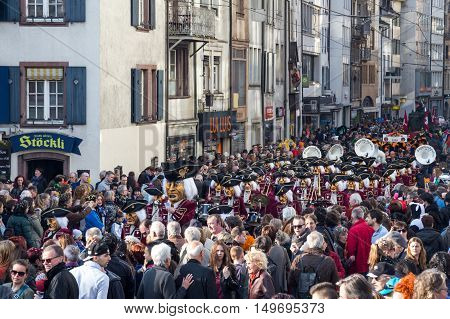 Basel, Switzerland - March 10, 2014: Spectators watching the tradtional carnival parade with dressed up people