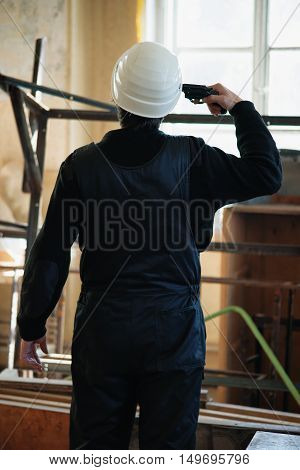 Engineer at consruction site with gun in his hand