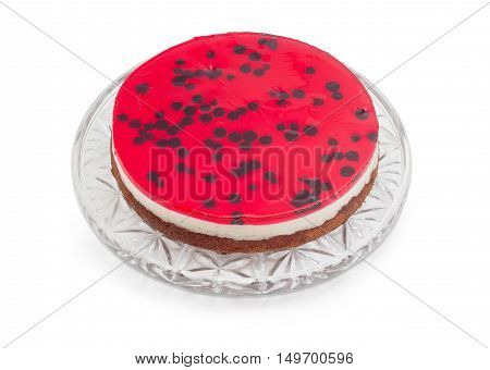Layered cake with with layers of sponge cake milk jelly and berry jelly on a glass cake serving dish on a light background