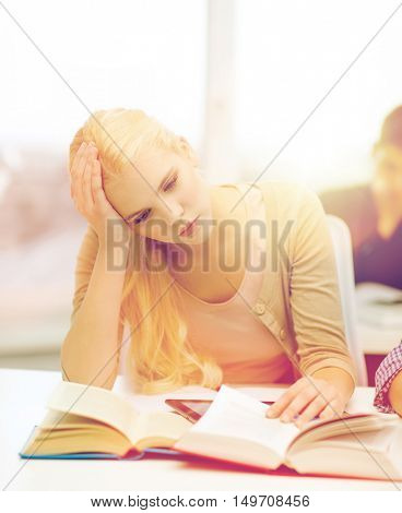 education, technology and internet concept - tired teenage girl student with tablet pc and books preparing for exam