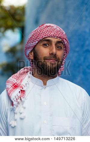 Young smiling handsome arabic man wearing traditional clothes
