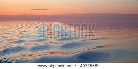 Soft wavy colorful water texture at sunrise