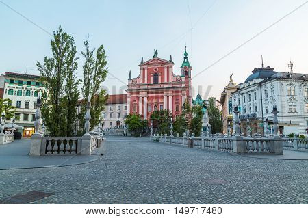 LJUBLJANA SLOVENIA - 27TH MAY 2016: The outside of Franciscan Church of the Annunciation The Triple Bridges and Preseren Square in Ljubljana in the morning