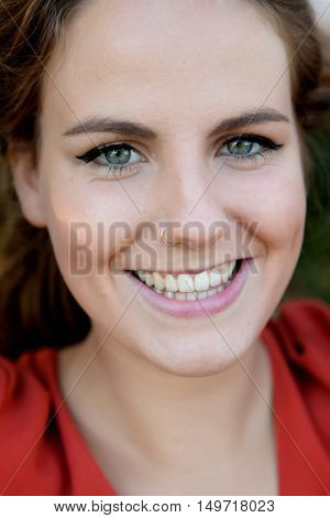 Portrait of young beautiful smiling woman with a pirsing in her nose