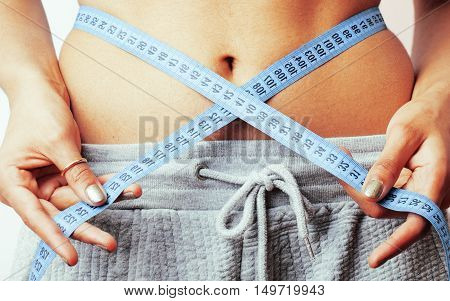 woman measuring waist with tape on knot like a gift, african tann isolated close up white background