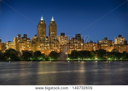 Upper West Side and Central Park Reservoir at twilight. Long exposure reveals star trails and accentuates building lights. Manhattan, New York City