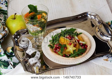 Dietary salad with orange, pomegranate and carom, centimeter for a good figure, a tray