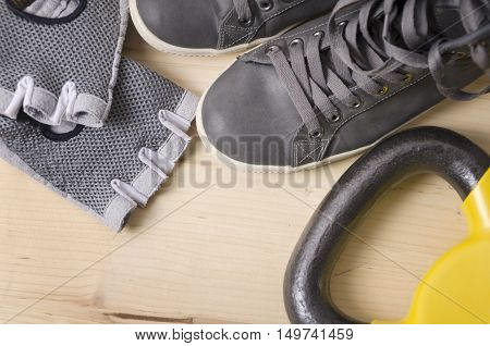 Pair of sport shoes glowes and kettlebell. Workout setting.