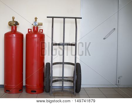 fire extinguishing system in the office. fire cylinders and transport trolley stand by the wall in an office building