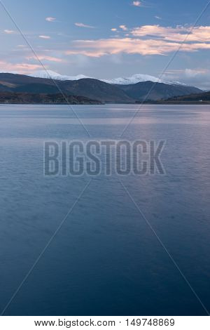 Snowcapped mountains by the sea at Ullapool Scotland