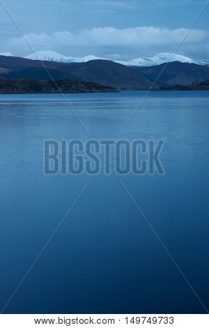 Snowcapped mountains by the sea at Ullapool Scotland