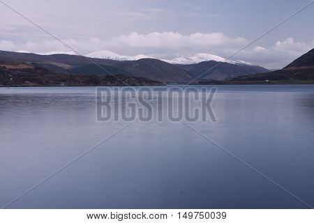 Snowcapped mountains by the sea at Ullapool Scotland
