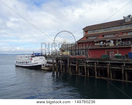 SEATTLE - JUNE 24 2016: Argosy Boat parked at the Docks of the Pier District in Seattle Washington with the Great Wheel in the Distance in Seattle during the summer on June 24 2016.