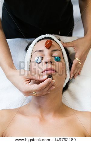 Beautiful Young Woman Receiving Gemstone Therapy In Spa.