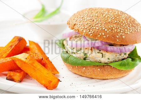 Burger with turkey, spinach, onion and roasted sweet potato, batat on a white background