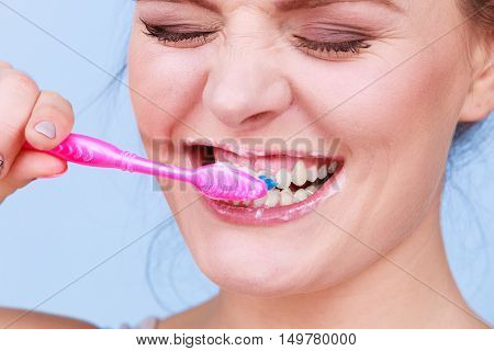 Woman brushing cleaning teeth. Girl with toothbrush. Oral hygiene. Blue background