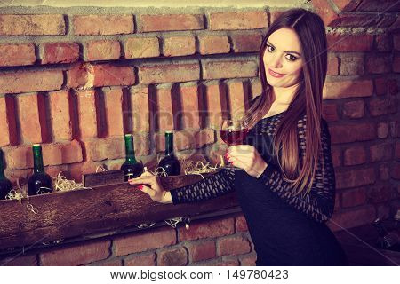 Woman Tasting Wine In Rural Cottage Interior