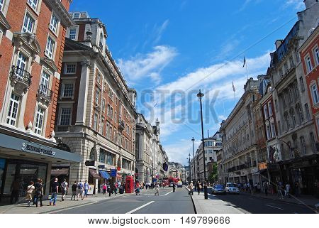 London, United Kingdom - July 7, 2014. View of Piccadilly street in London, with historic buildings, commercial properties, street traffic and people.
