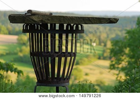 a empty portable BBQ grill in front of a fresh green summer landscape