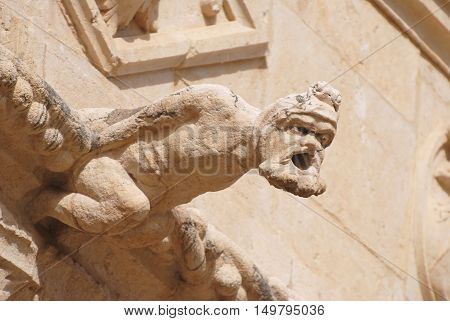 Lisbon, Portugal - October 21, 2014. Gargoyle representing a human figure at the upper balustrade of Mosteiro dos Jeronimos in Lisbon.