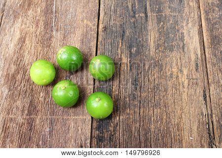 lemon with green on the wooden table top view