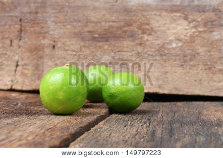 lemon with green closeup Select focus with shallow depth of field on the wooden