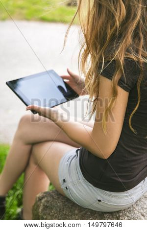 young woman with a tablet sitting on the road universally wireless connection and social media